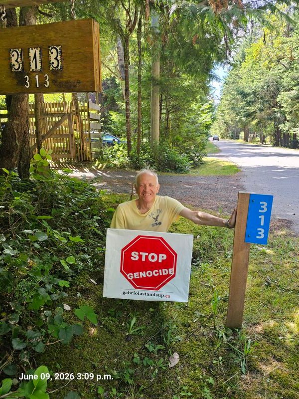 Andrzej with his Stop Genocide sign on Malaspina Drive, Gabriola