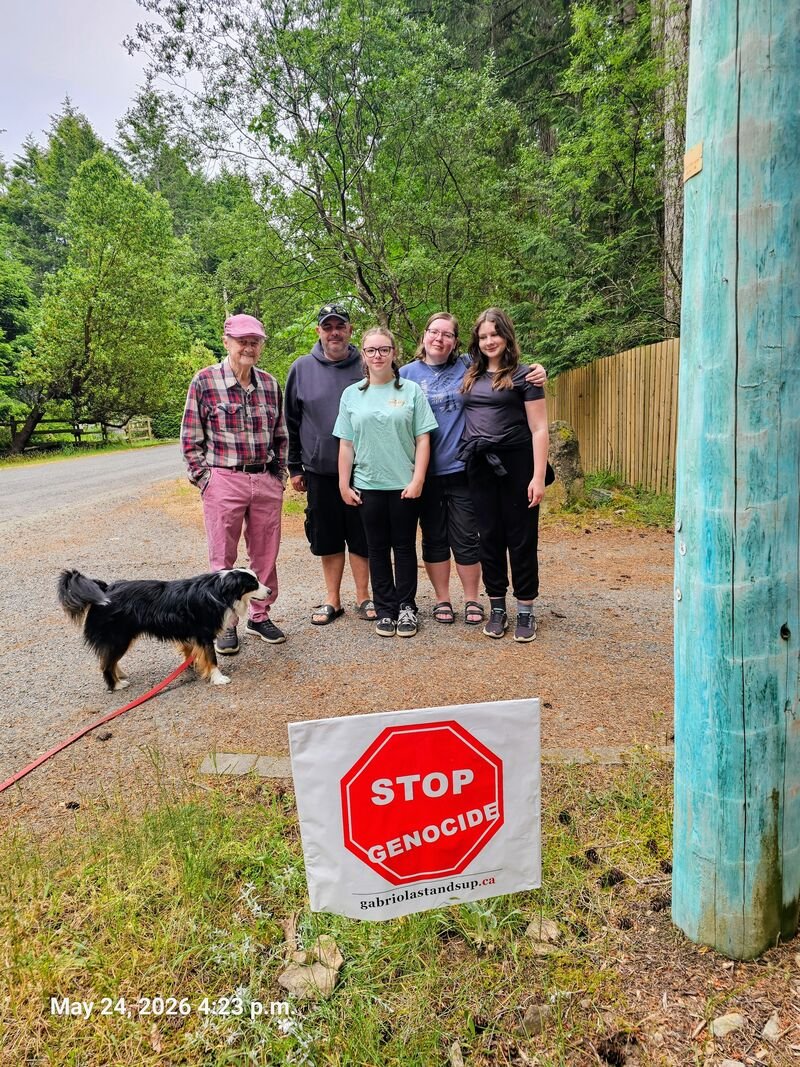 Daryl, Michelle and Steve with their Stop Genocide sign on Wild Cherry Terrace, Gabriola