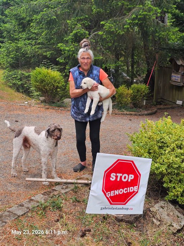 Diane with her Stop Genocide sign on Wild Cherry Terrace, Gabriola