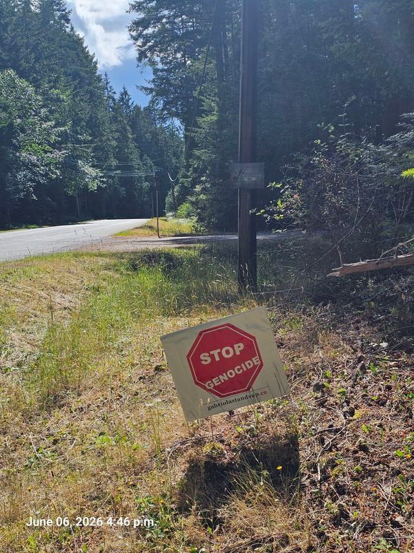 Stop Genocide sign at corner of Eva Road and North Road, Gabriola