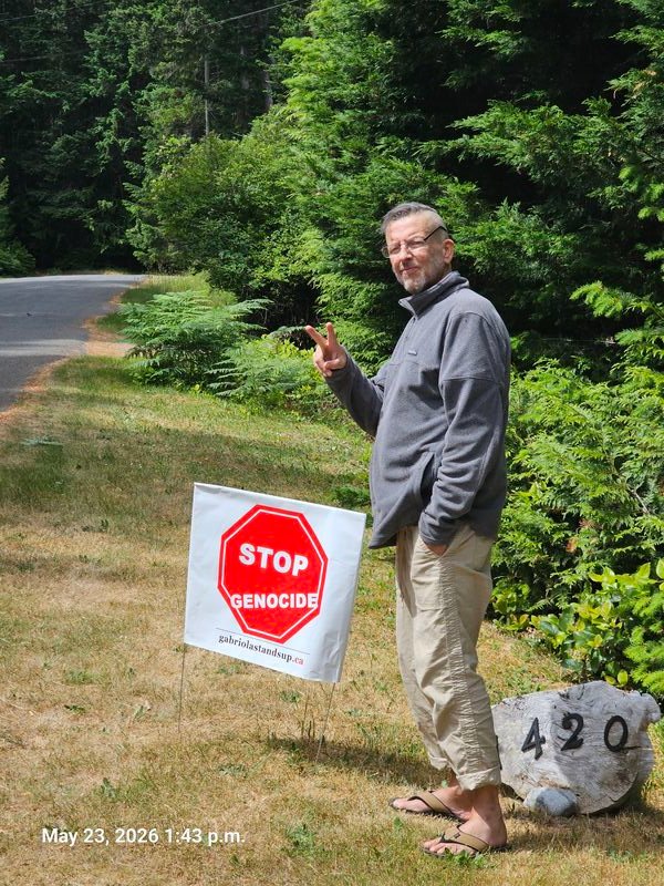Jason with his Stop Genocide sign on Wild Cherry Terrace, Gabriola