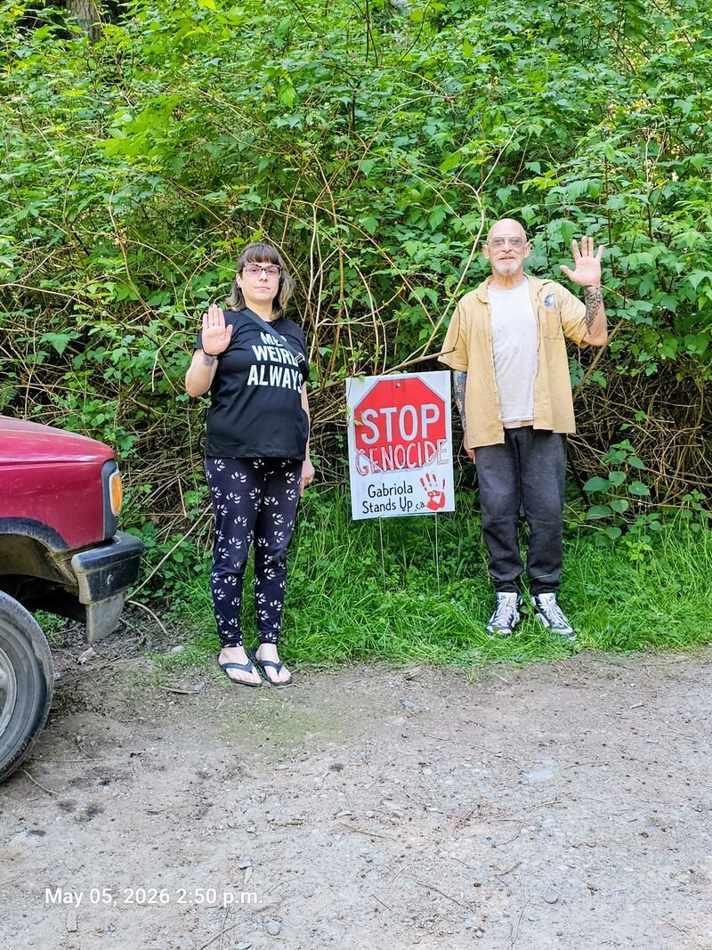 Larry and his neighbour with their Stop Genocide sign on Christine Place, Gabriola