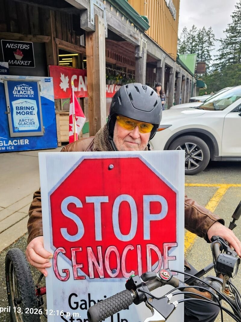 Stevie B with his Stop Genocide sign outside Nesters Market, Gabriola